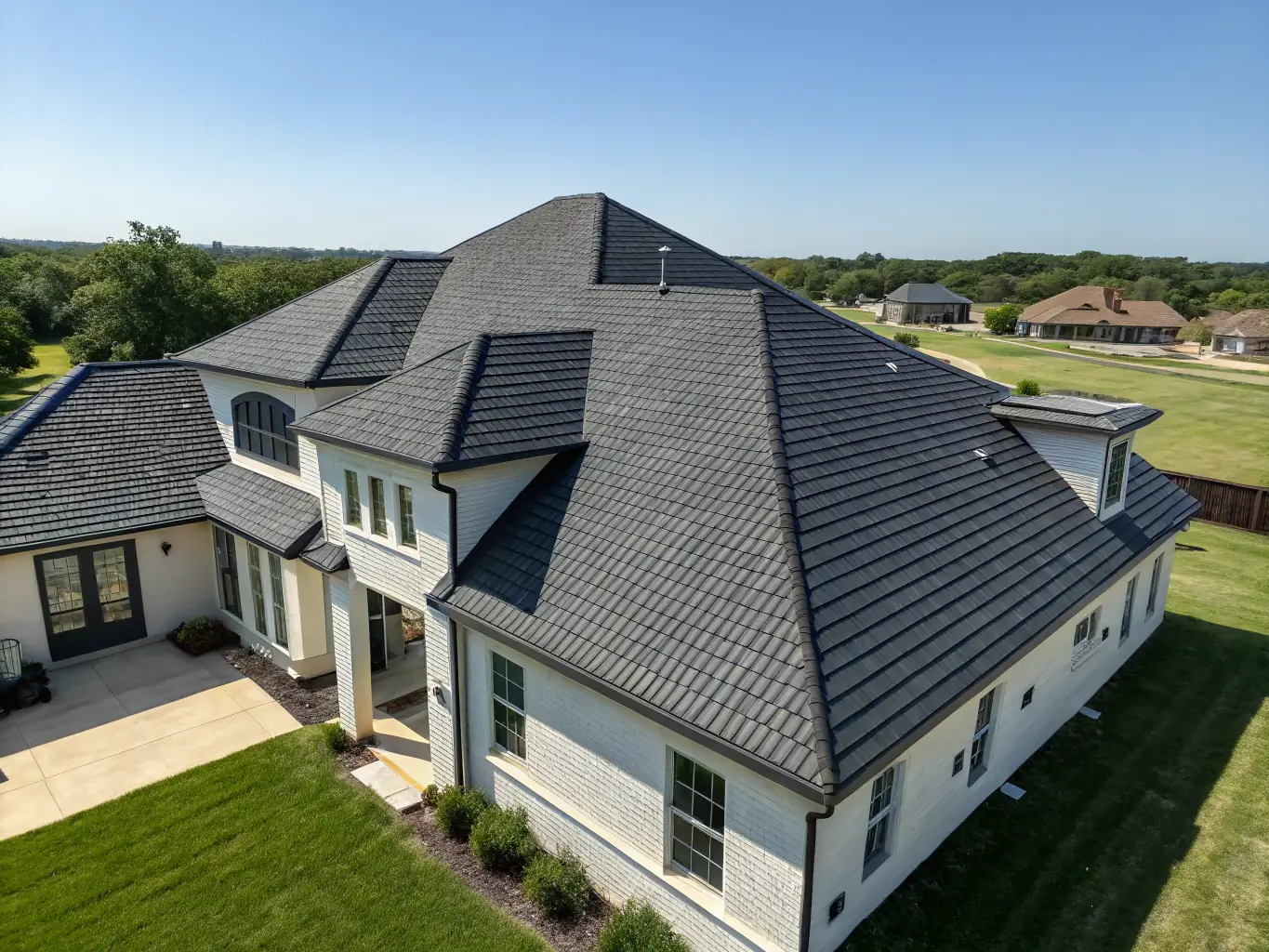 A high-angle shot of a newly installed shingle roof on a residential home, showcasing the quality and craftsmanship of Reese Roofing & Construction. The image should highlight the clean lines and durable materials used.